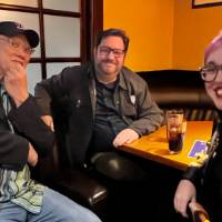 Three alums sitting together at a table.
